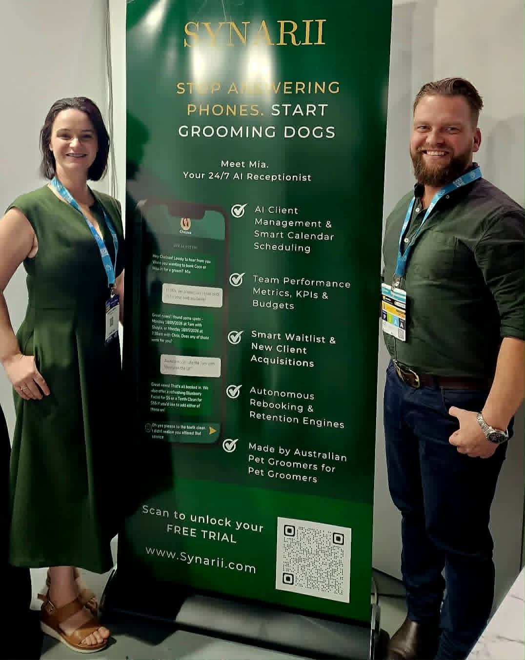 Chris and Shayla beside the Synarii banner at a pet industry expo